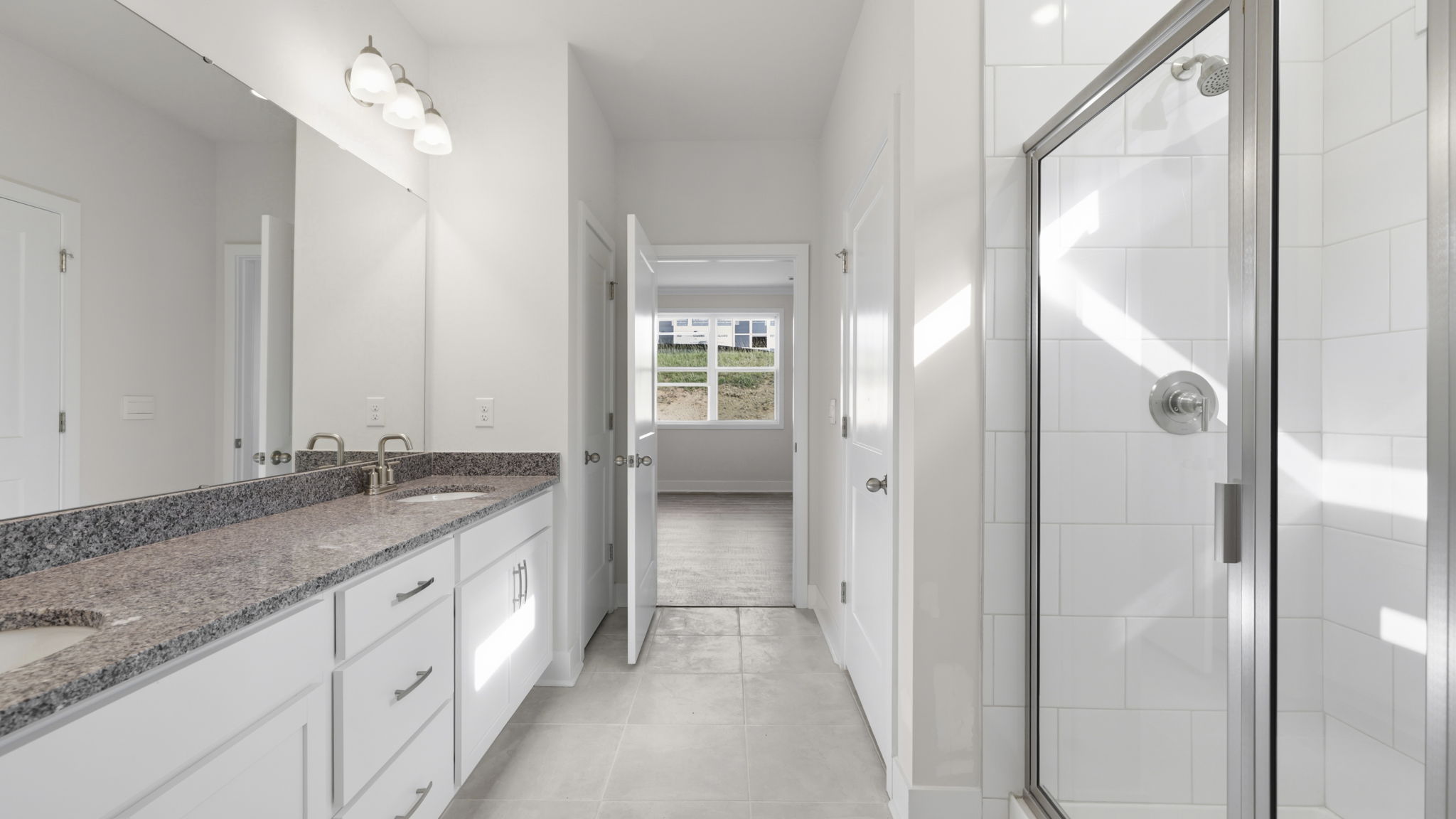 Primary ensuite bathroom with dual vanity, large walk in shower and walk in closet
