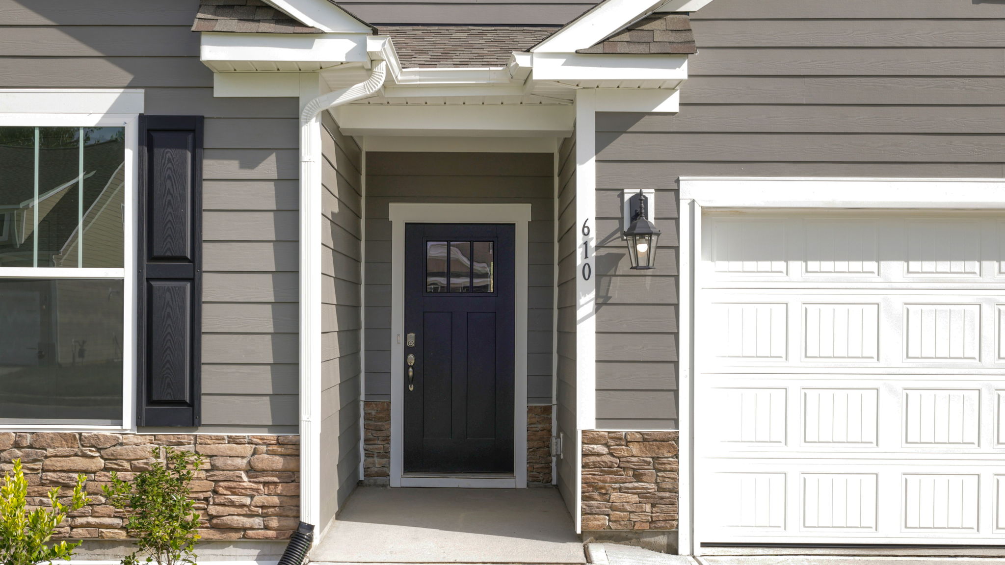 Close up exterior view of front door and partial view of garage