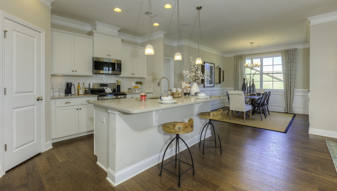 Kitchen and  island, white counters and cabinets, wood floors