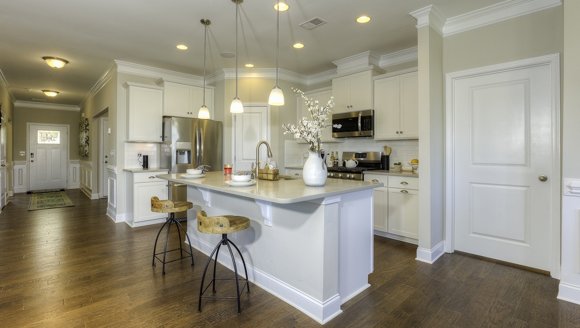 Kitchen and  island, white counters and cabinets, wood floors
