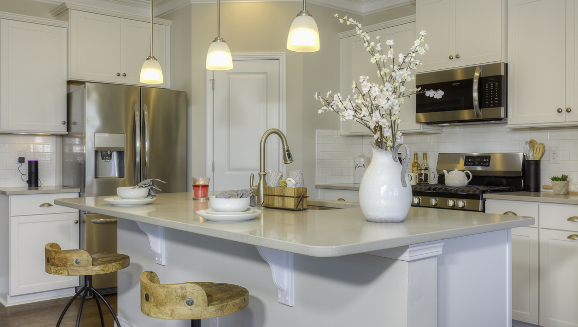 Kitchen and  island, white counters and cabinets, wood floors