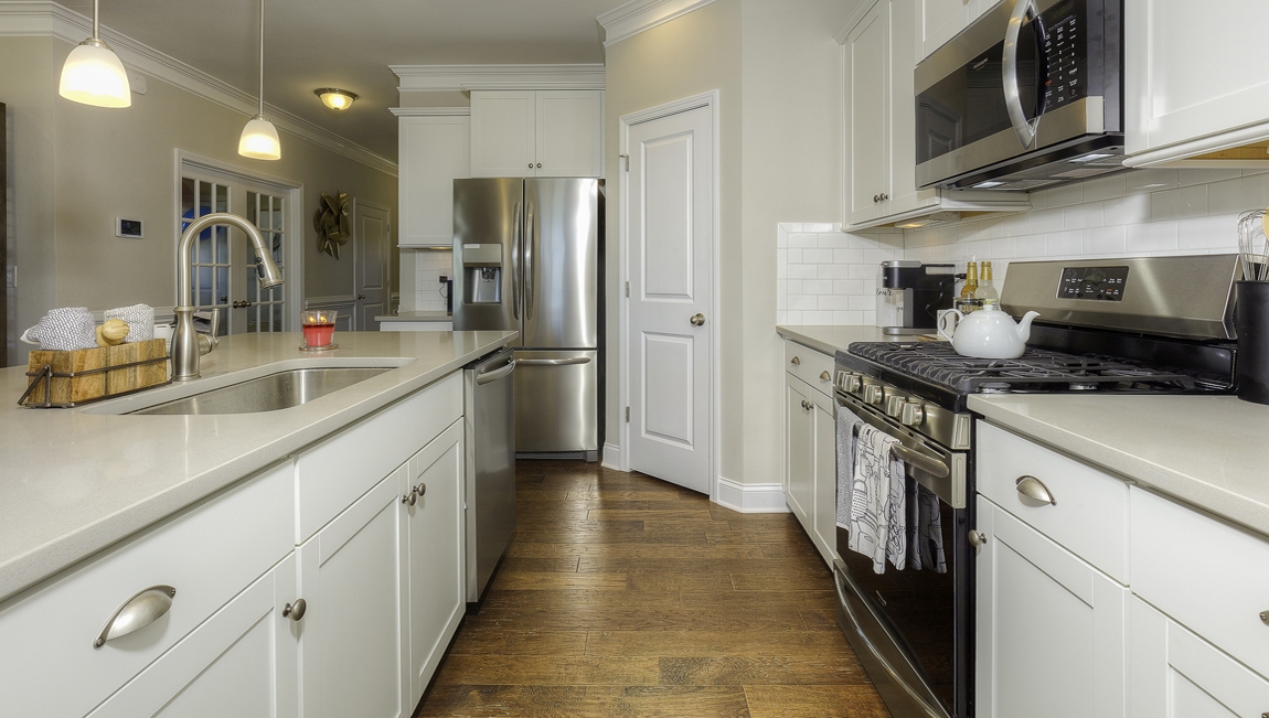 Kitchen and  island, white counters and cabinets, wood floors