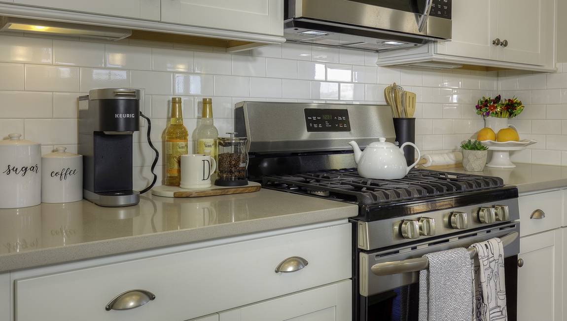 Kitchen and  island, white counters and cabinets, wood floors