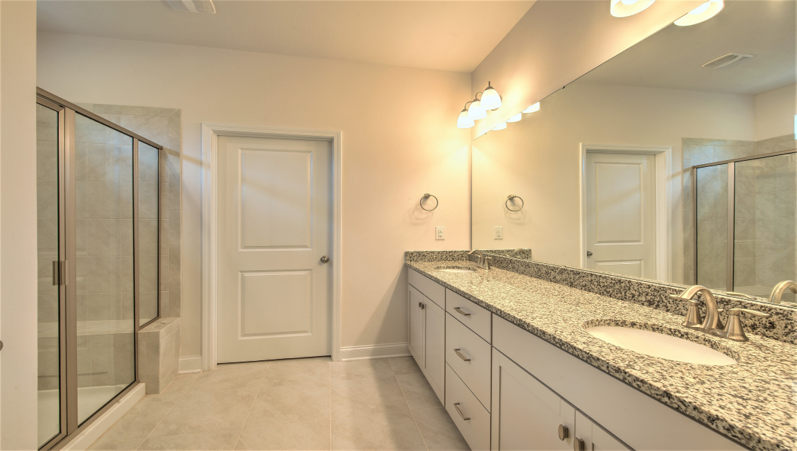 Primary bathroom with double vanity and walk in shower
