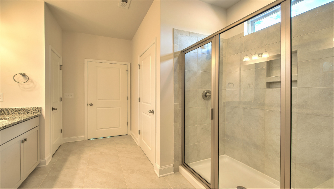 Primary bathroom with double vanity and walk in shower