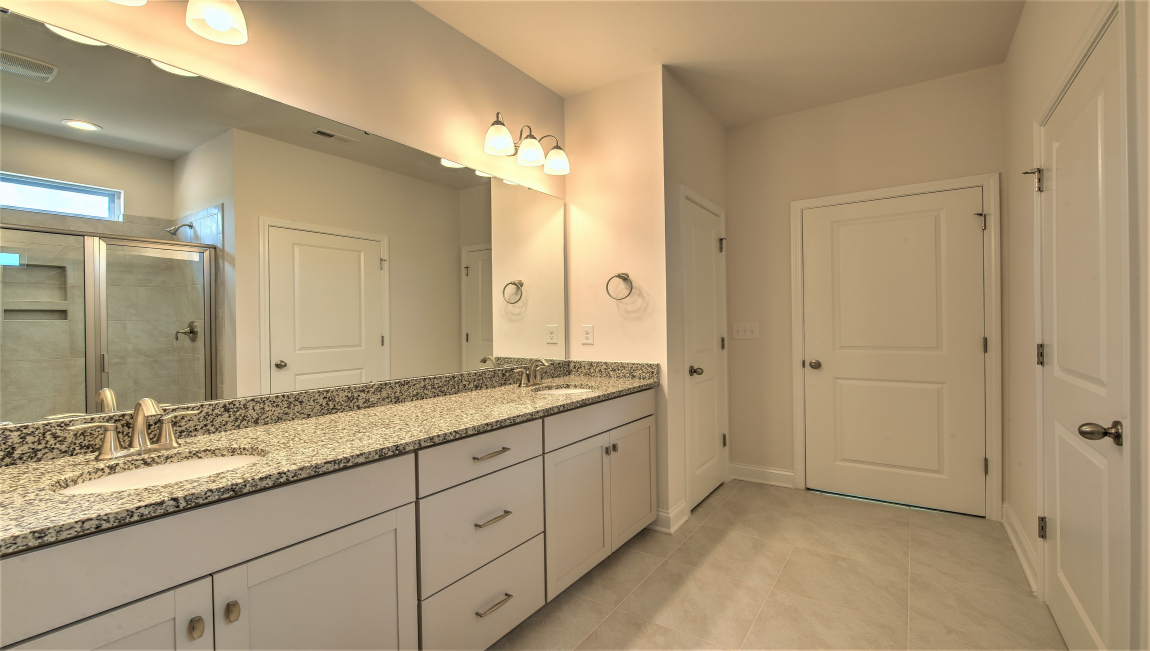 Primary bathroom with double vanity and walk in shower