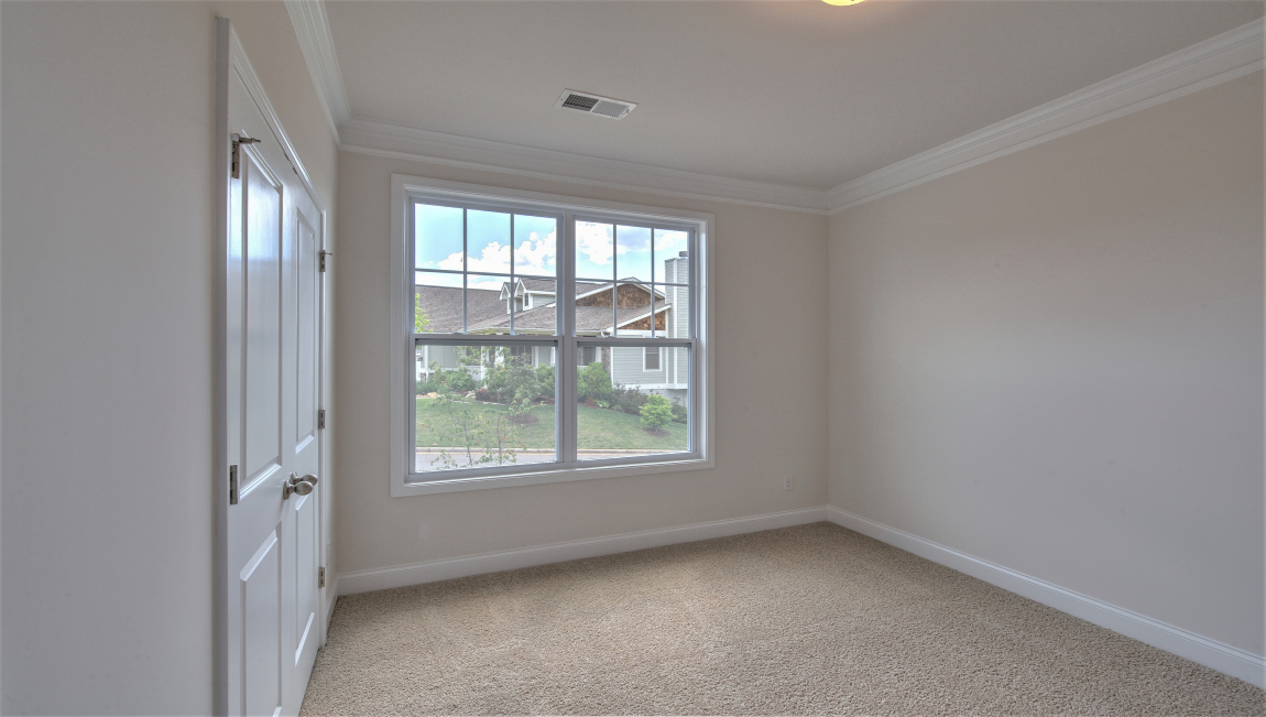 Carpeted bedroom with large window