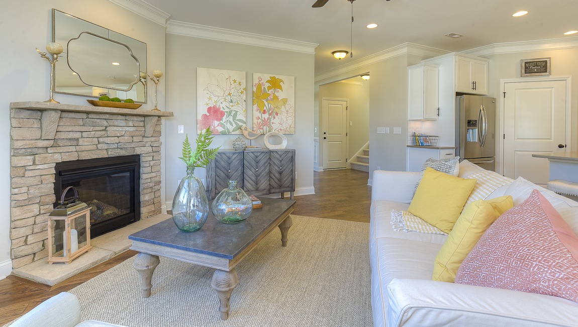Open family room in view of dining room, with wood floors, large window and fireplace