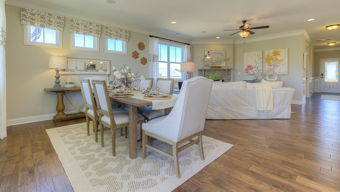 Dining room with wood floors, large windows, and back door to patio
