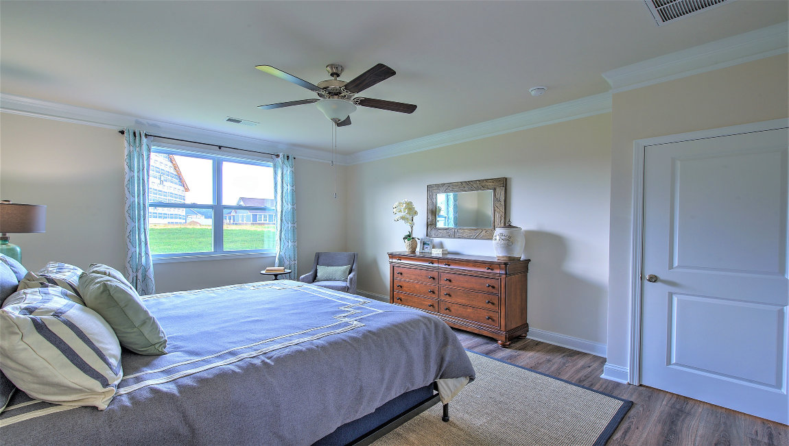 Bedroom with vinyl flooring, large window, and ceiling fan