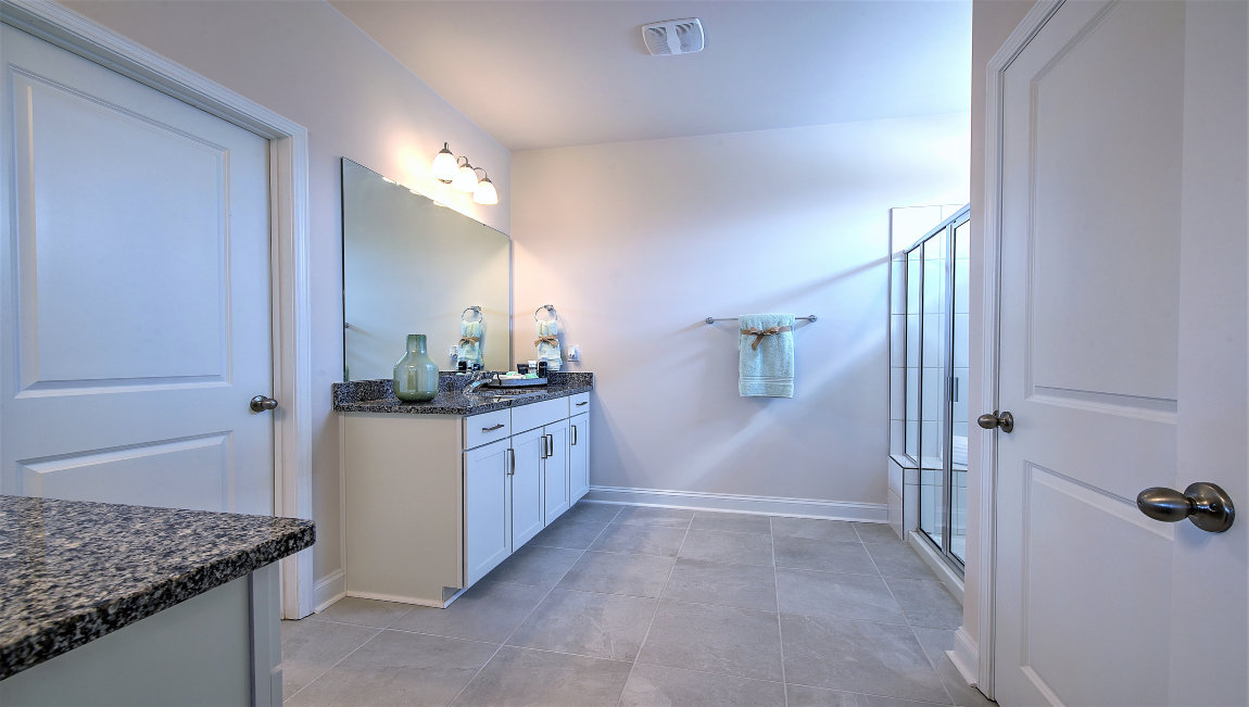 Bathroom with two counters and sinks, glass door shower