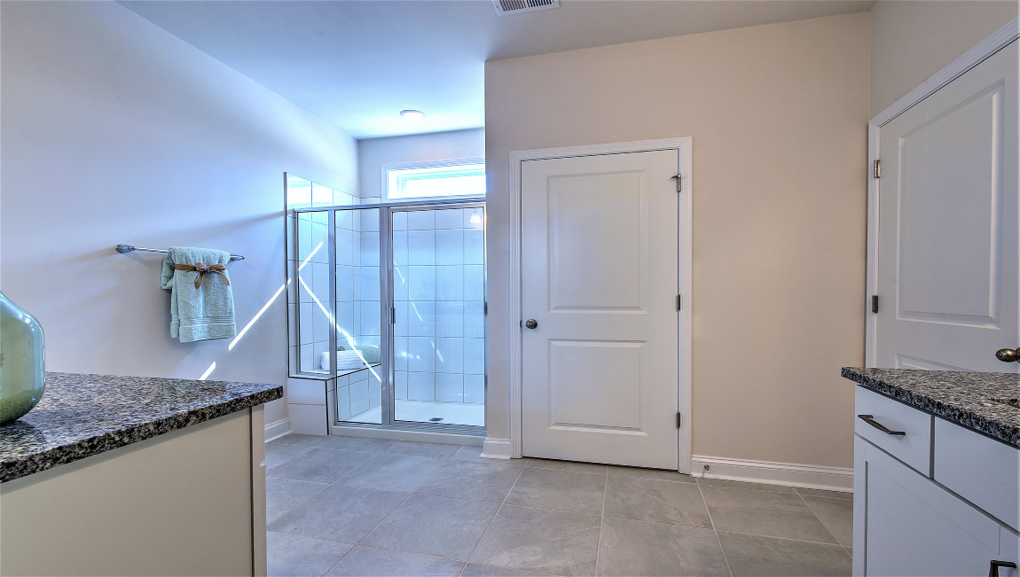 Bathroom with two counters and sinks, glass door shower