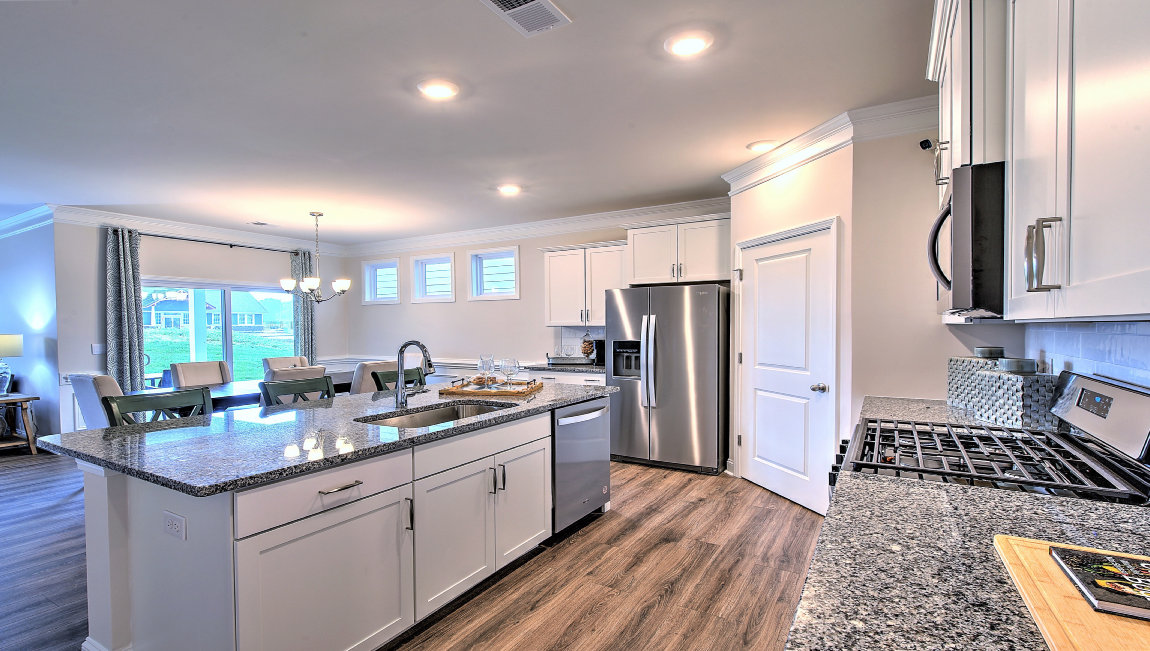 Kitchen and island, white cabinets, and stainless steel appliances