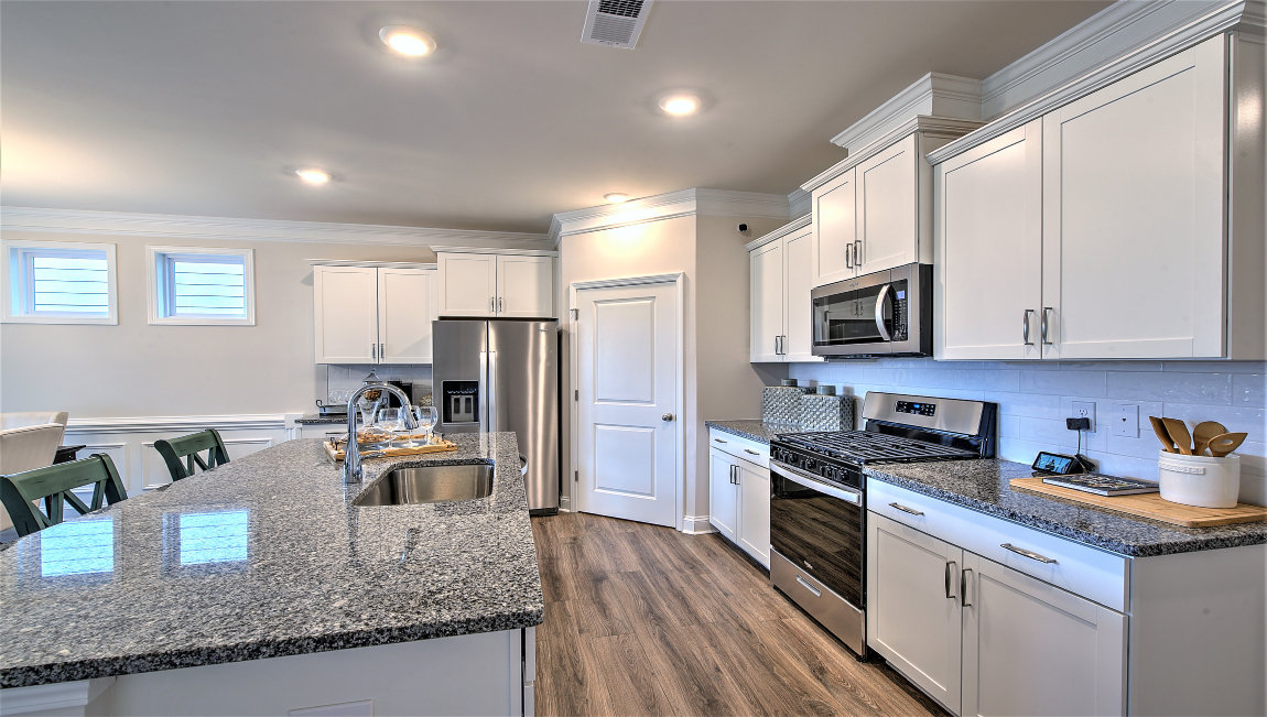 Kitchen and island, white cabinets, and stainless steel appliances