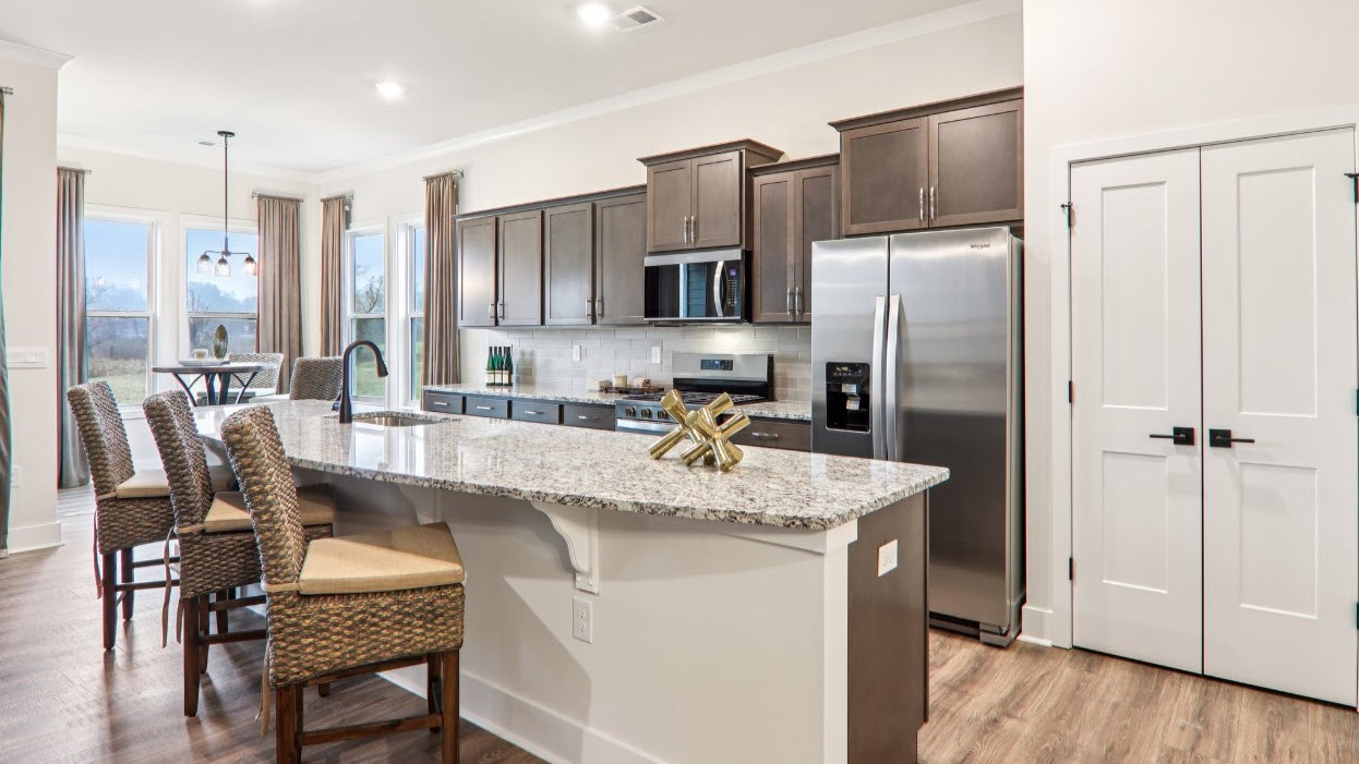 Open kitchen with ten foot island and stainless steel appliances