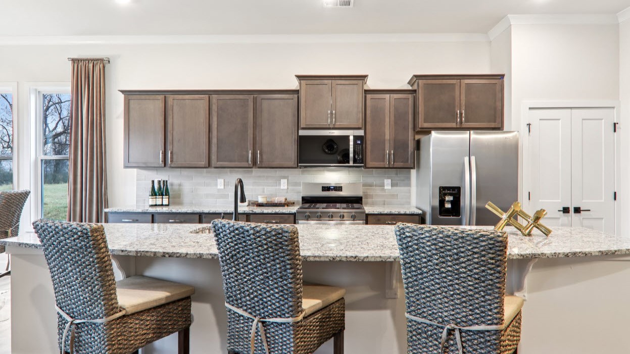 Open kitchen with ten foot island and stainless steel appliances