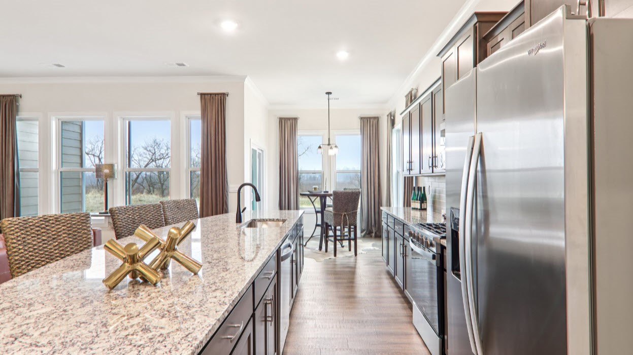 Open kitchen with ten foot island and stainless steel appliances