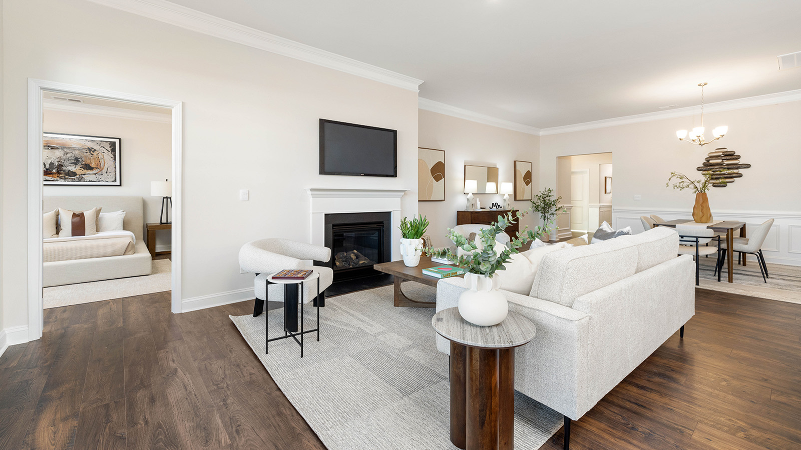 Open living room with wood floors, three windows, and fireplace