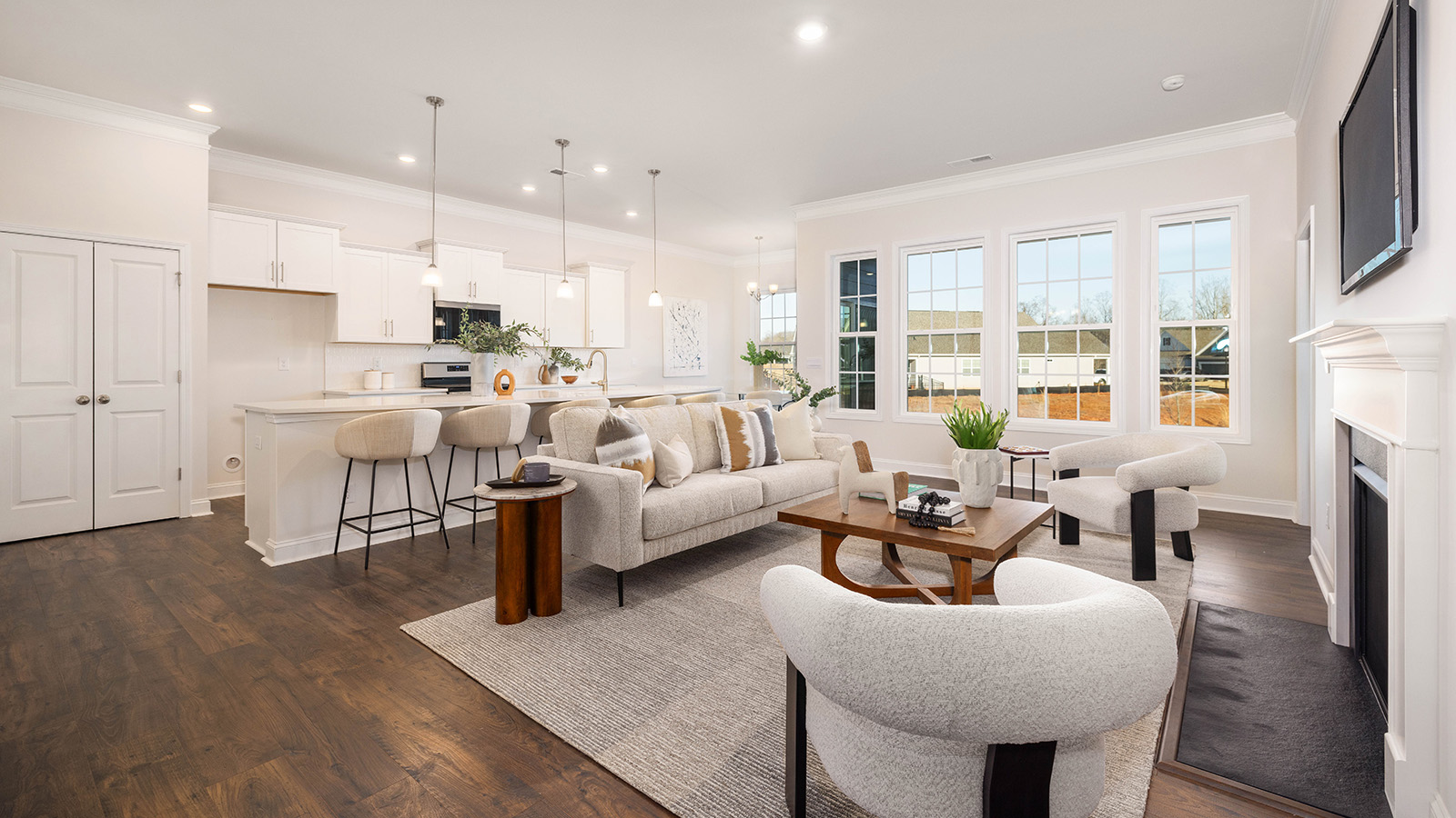 Open living room with wood floors, three windows, and fireplace