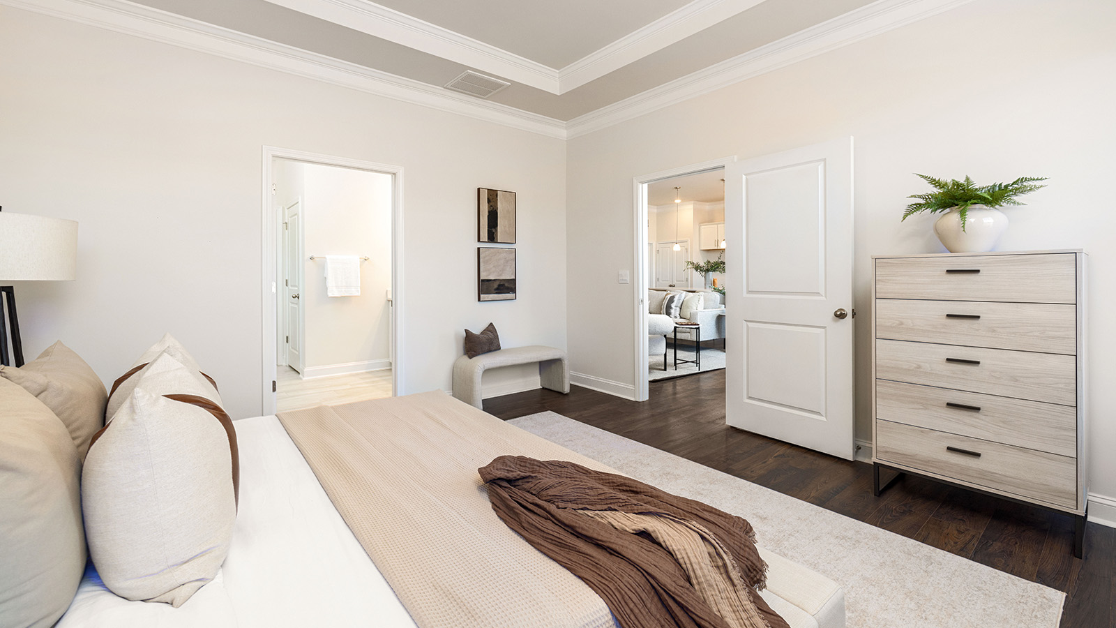 Primary bedroom with wood floors, and two large windows