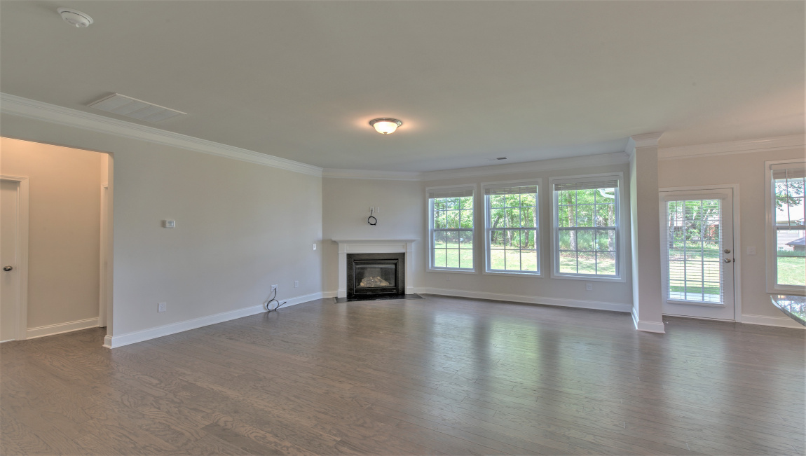 Large and open family room with large windows and gas fireplace