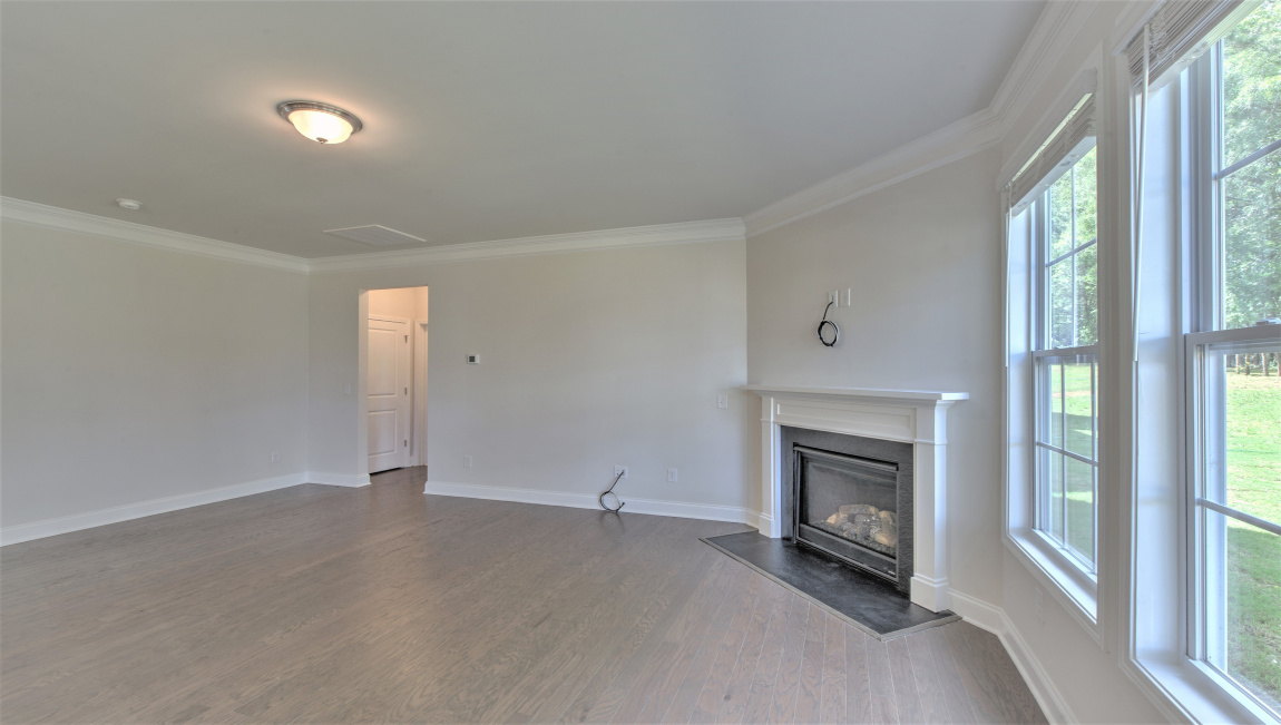 Large and open family room with large windows and gas fireplace