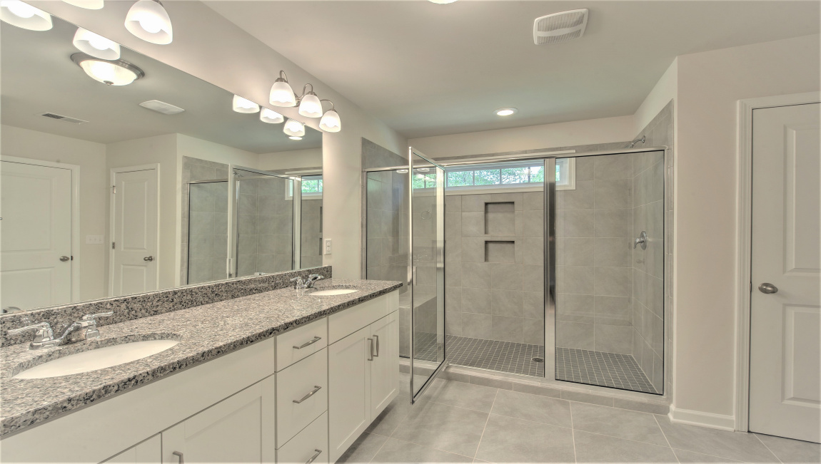 Primary bathroom with dual vanity and walk in shower