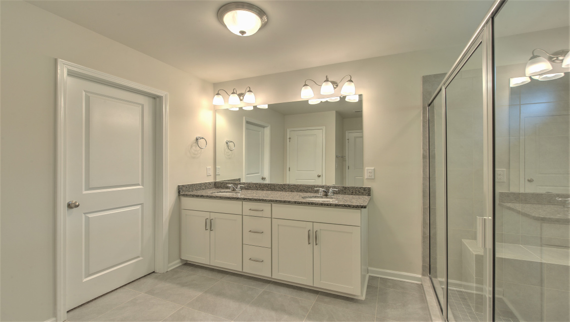 Primary bathroom with dual vanity and walk in shower