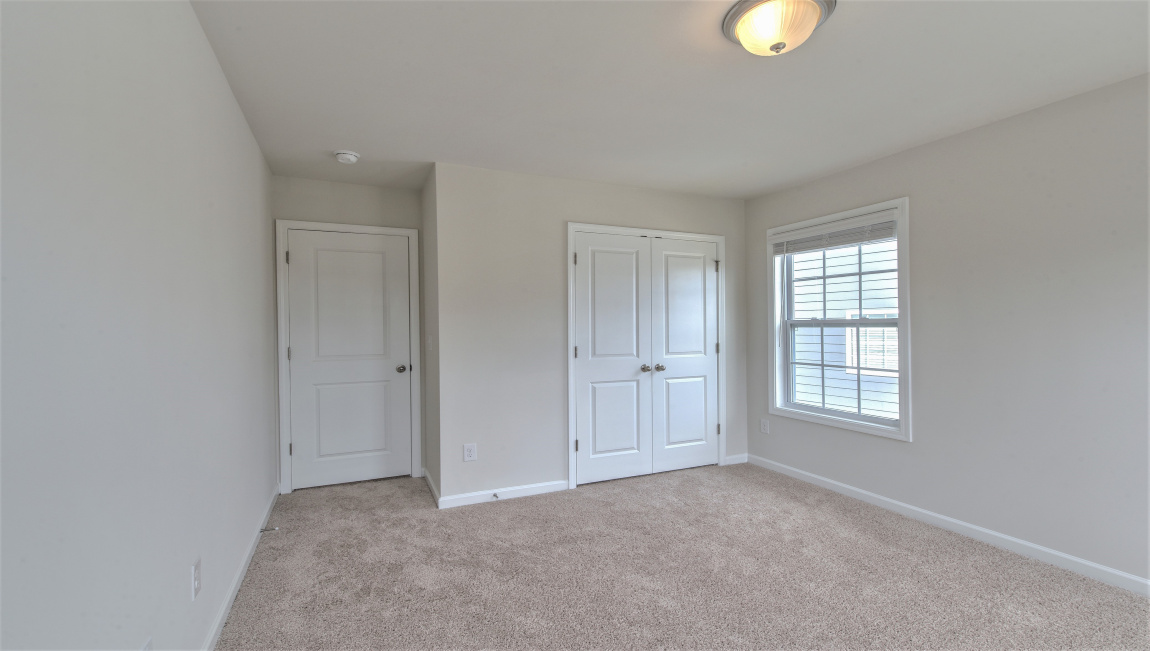 Large carpeted bedroom with multiple windows