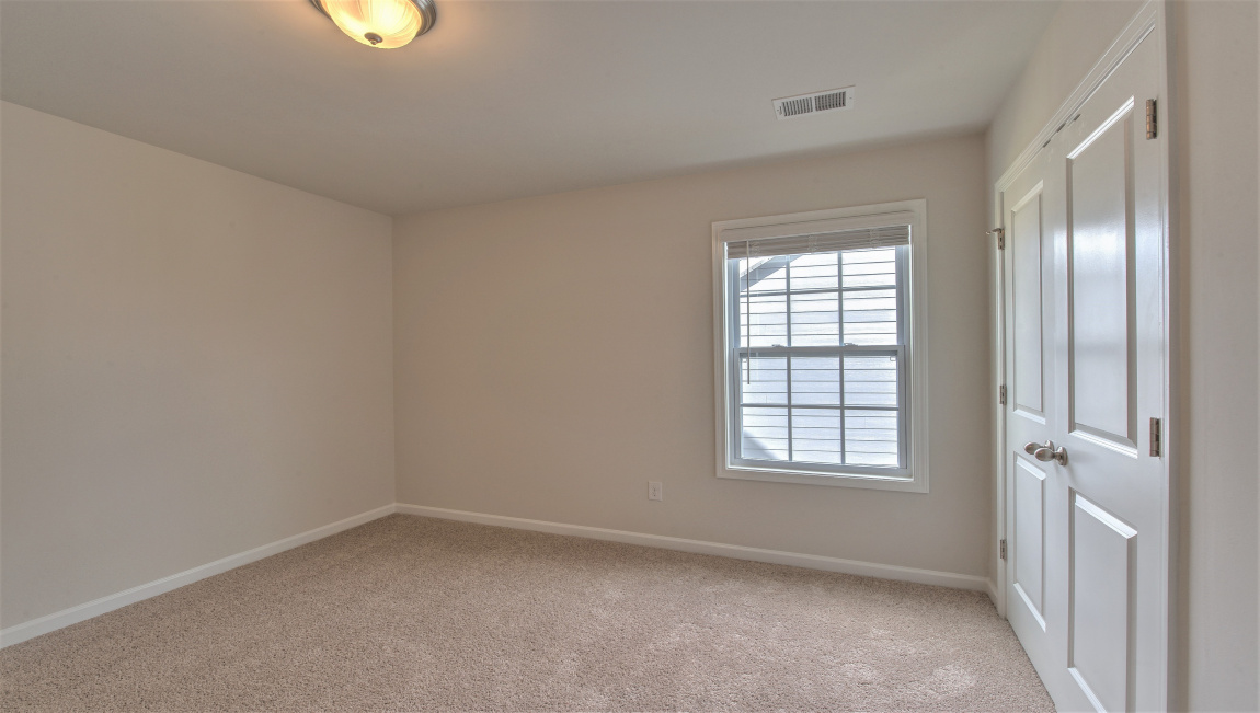 Large carpeted bedroom with multiple windows