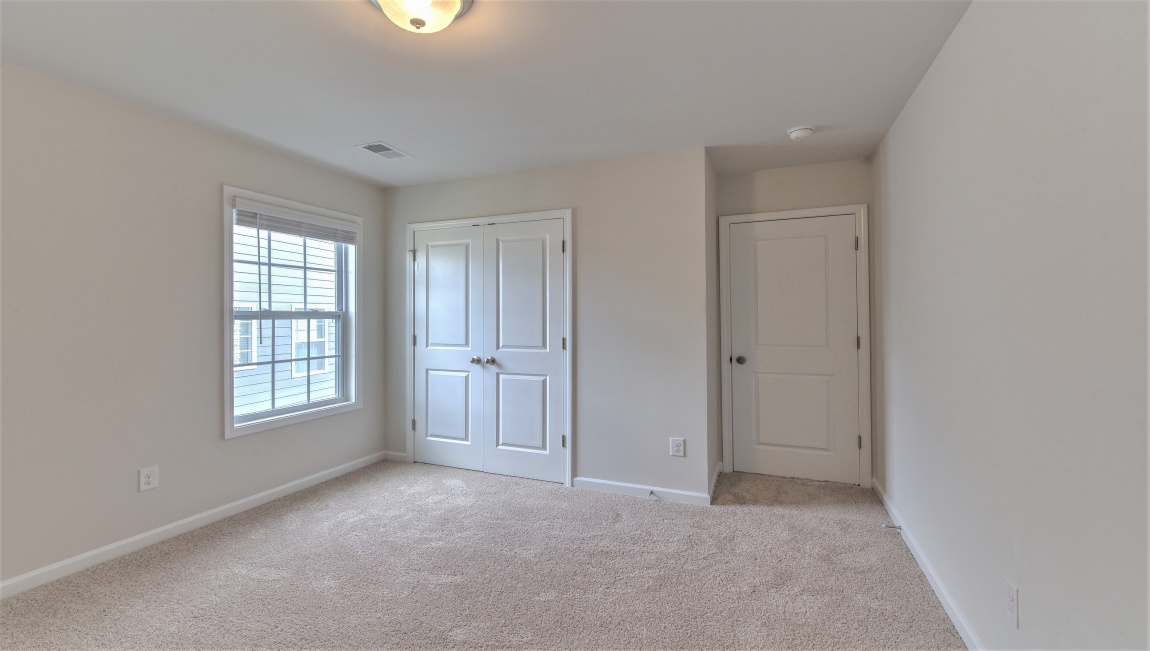 Large carpeted bedroom with multiple windows