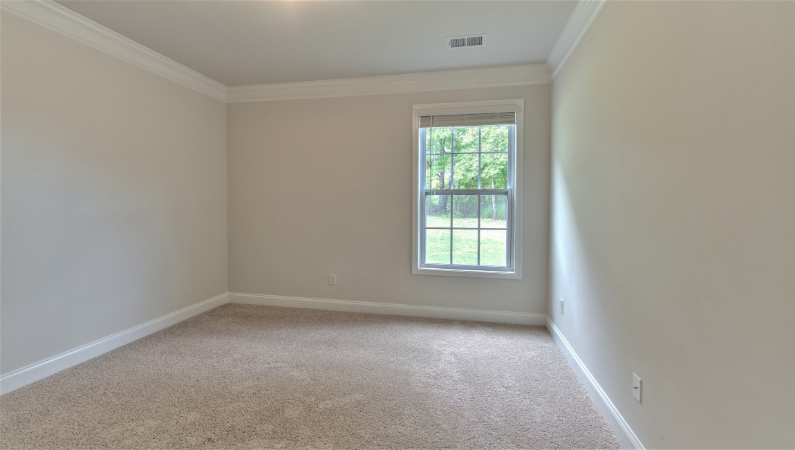 Large carpeted bedroom with multiple windows