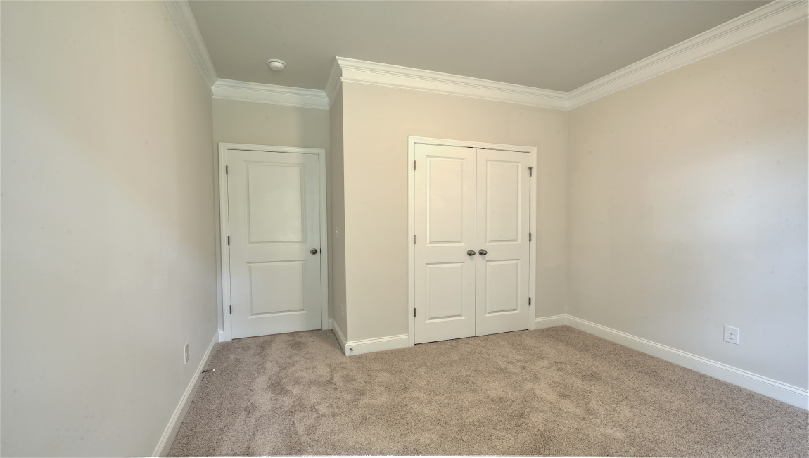 Large carpeted bedroom with multiple windows