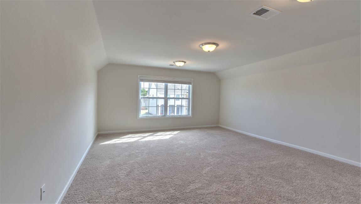 Large carpeted bonus room with windows