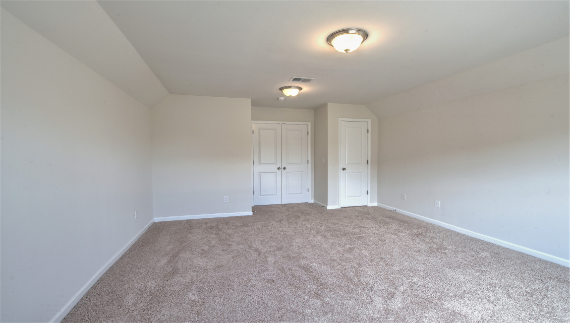 Large carpeted bonus room with windows