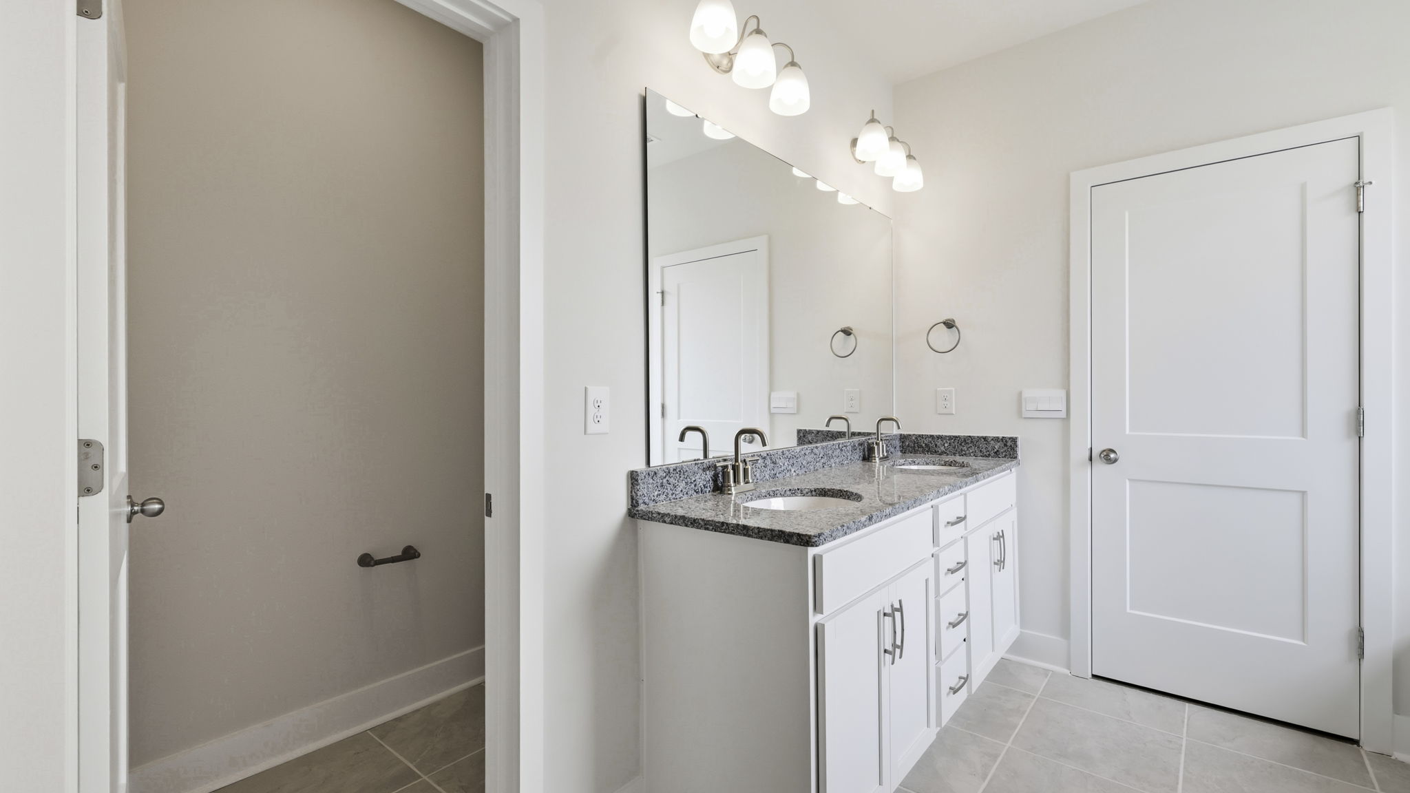 Primary bathroom with dual vanity and private toilet closet