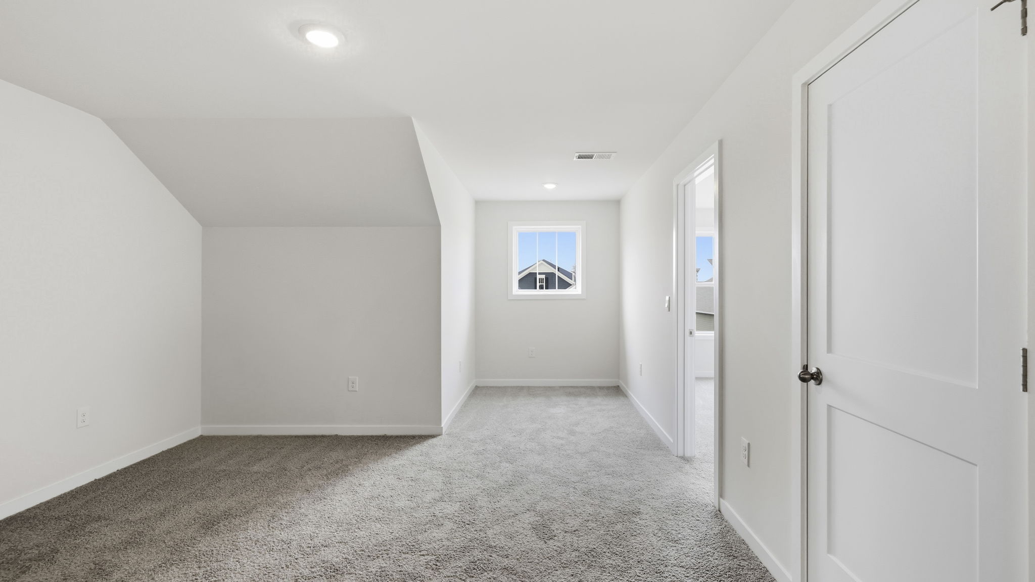 upstairs carpeted loft area with window