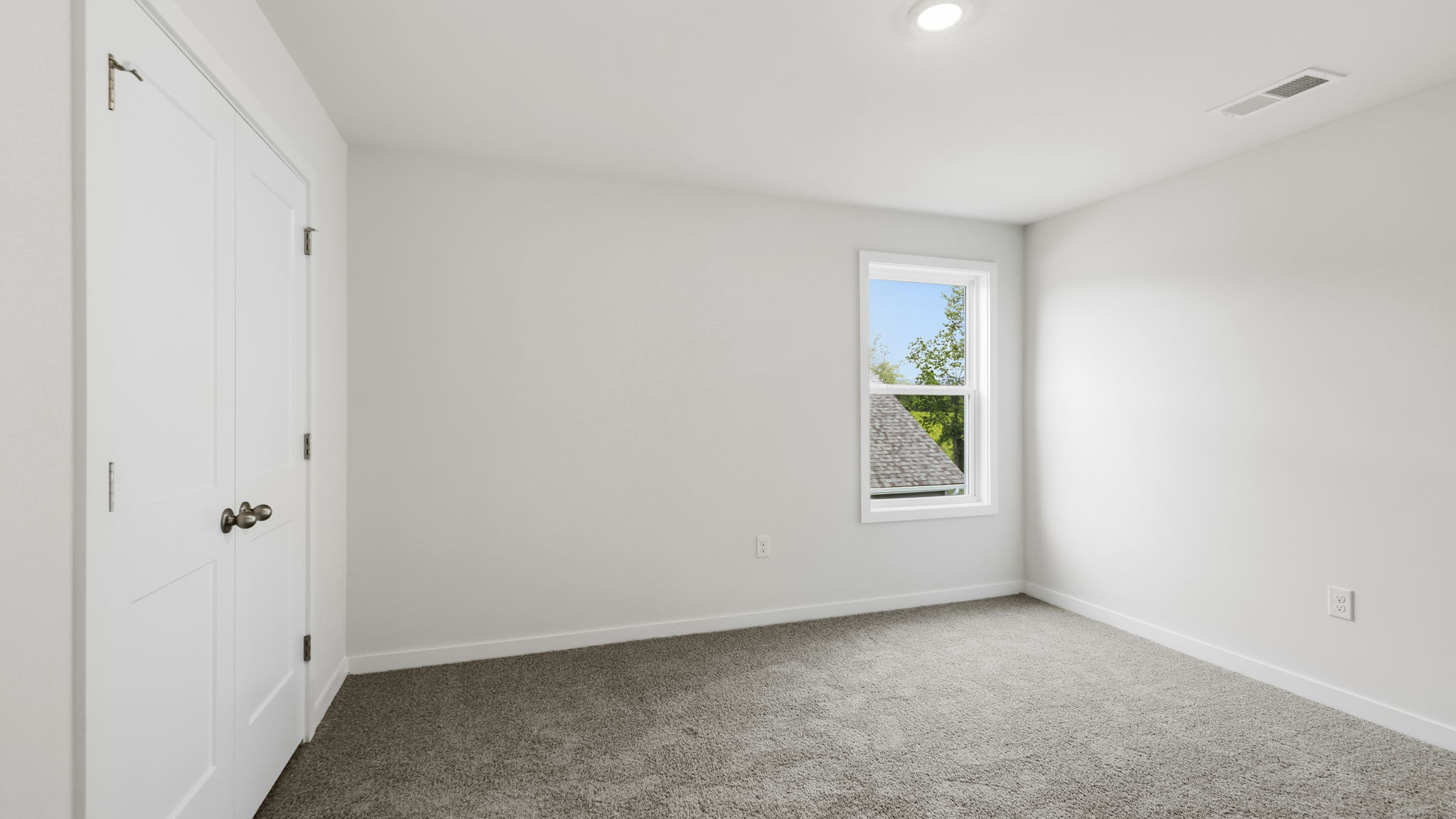 Carpeted bedroom with large window