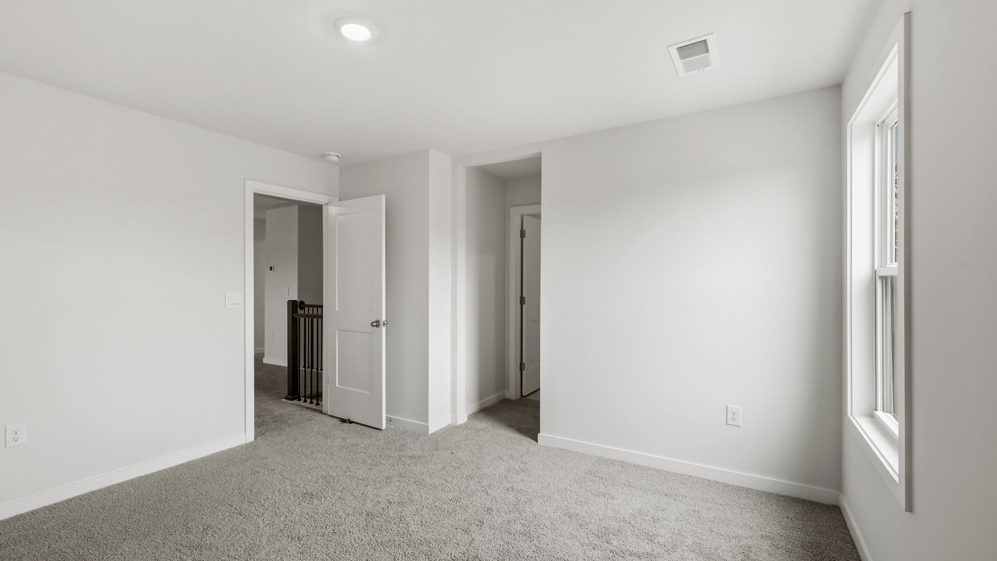 Carpeted bedroom with large window