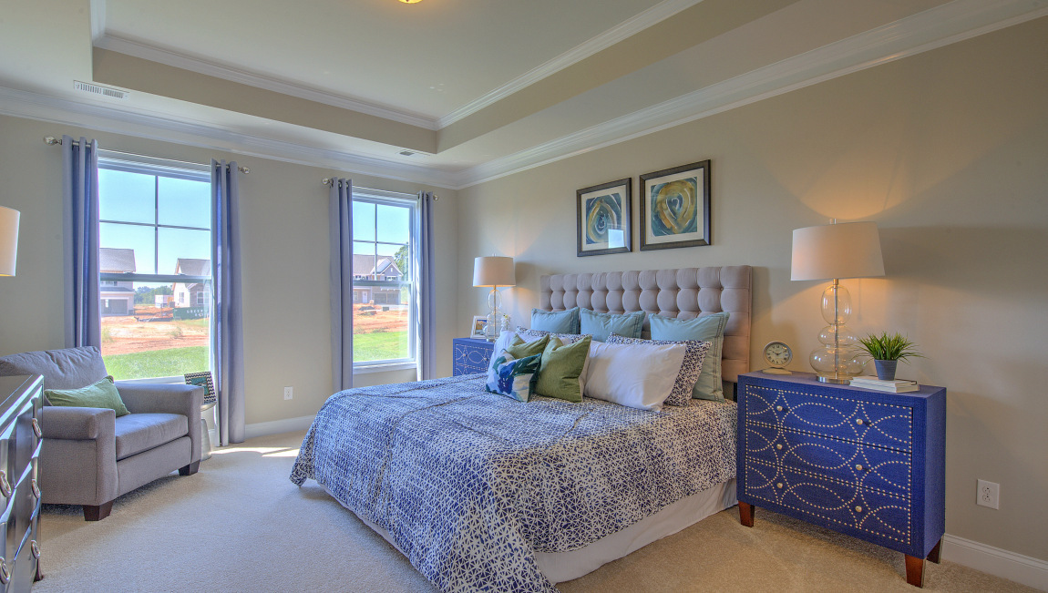 Carpeted primary bedroom with windows