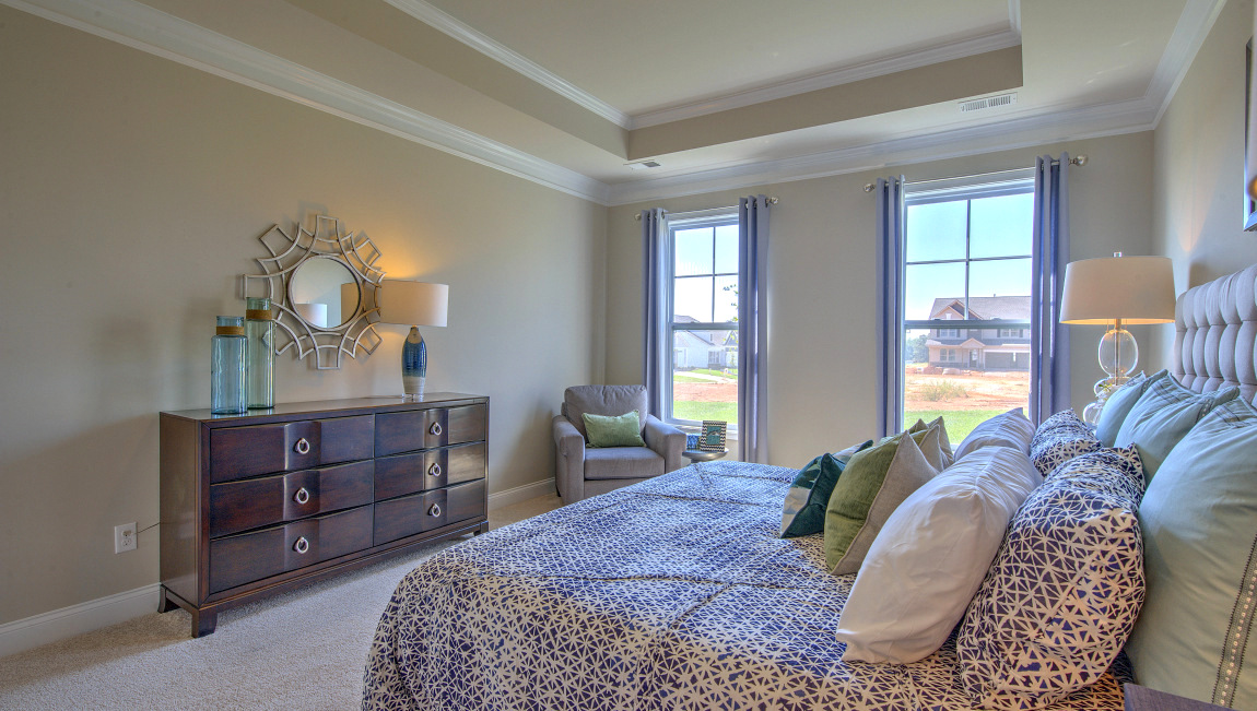Carpeted primary bedroom with windows