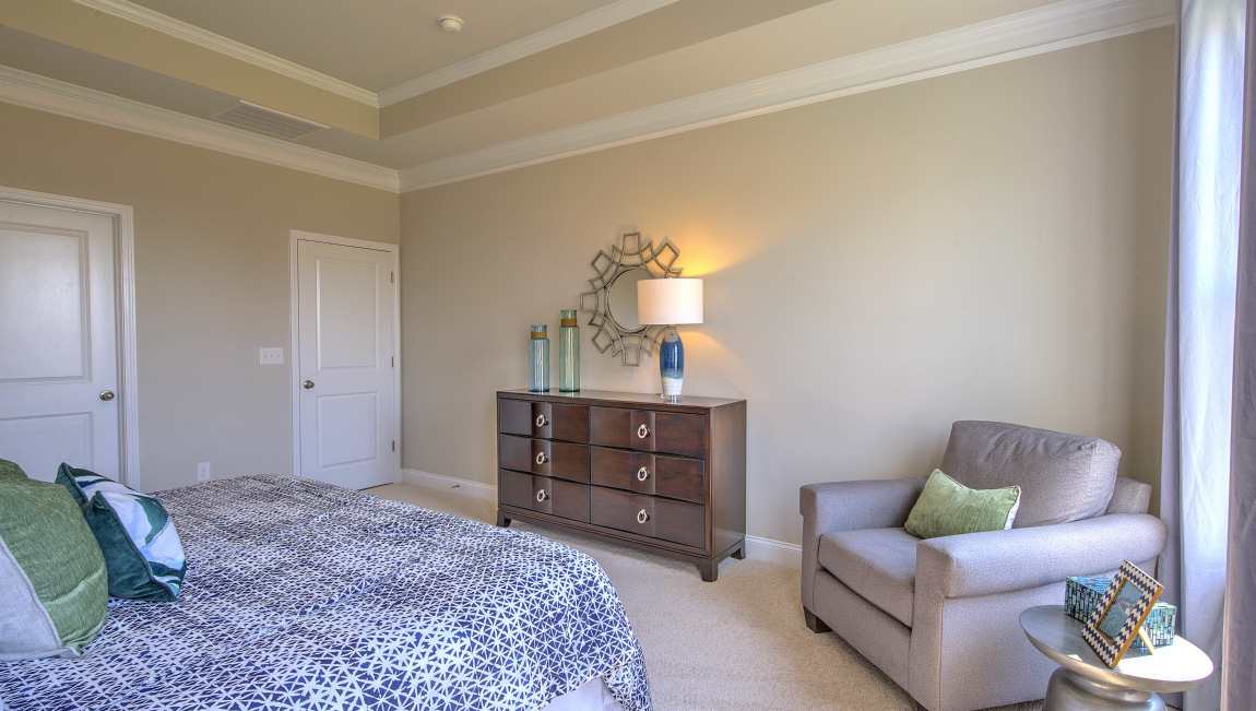 Carpeted primary bedroom with windows