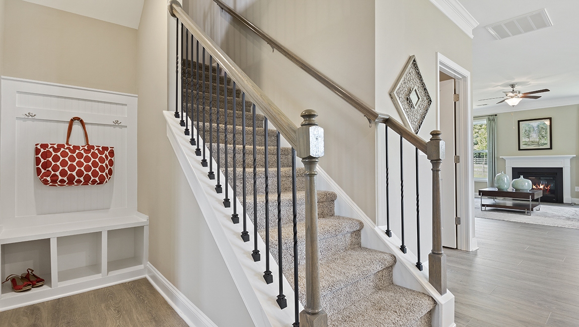 Carpeted stairs and a built in cubby space next to it.