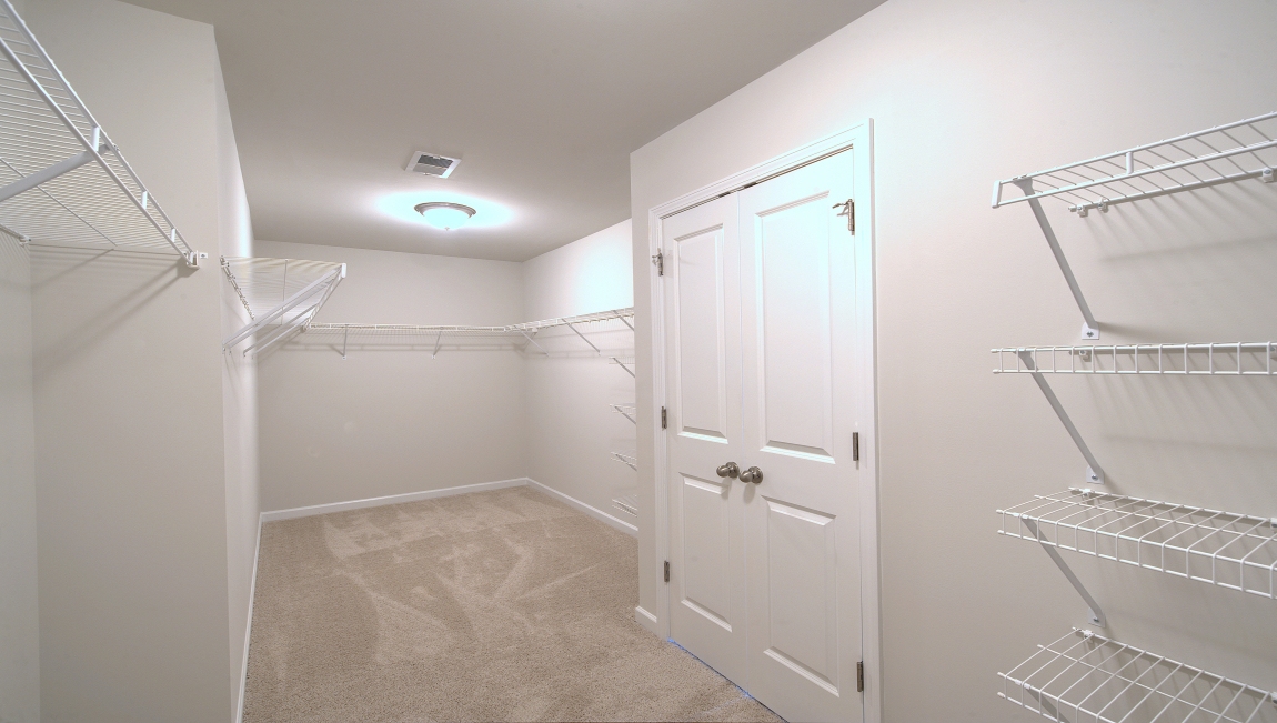 Primary walk in closet with shelving