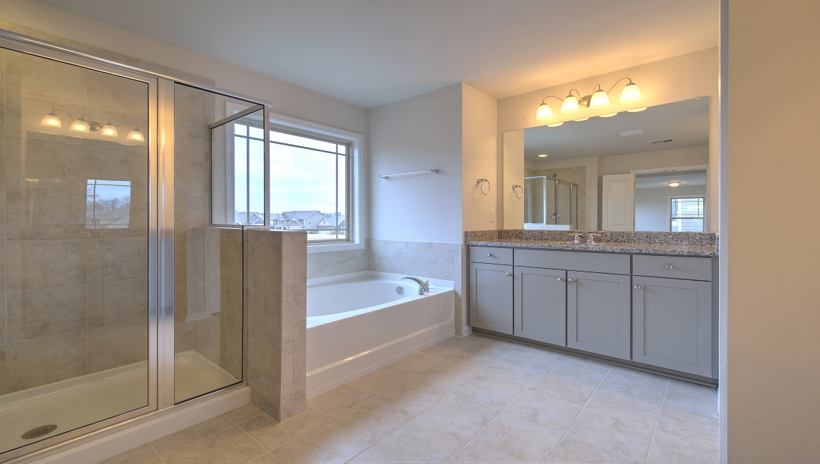 Primary bathroom with dual vanity, garden tub and walk in shower