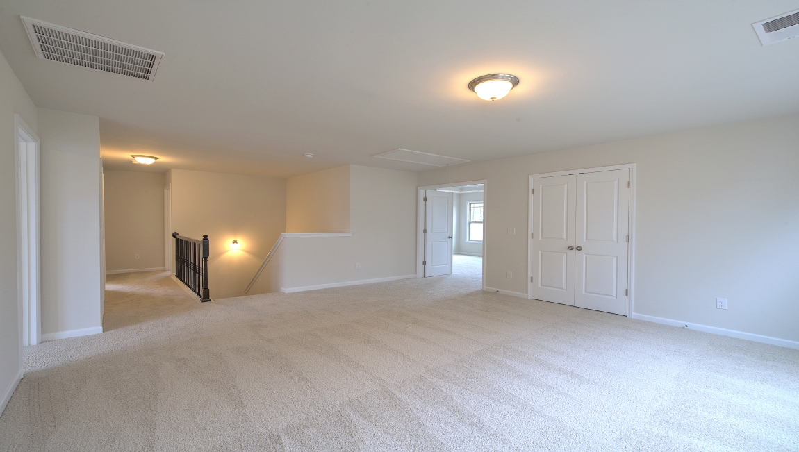 Carpeted rec room with windows