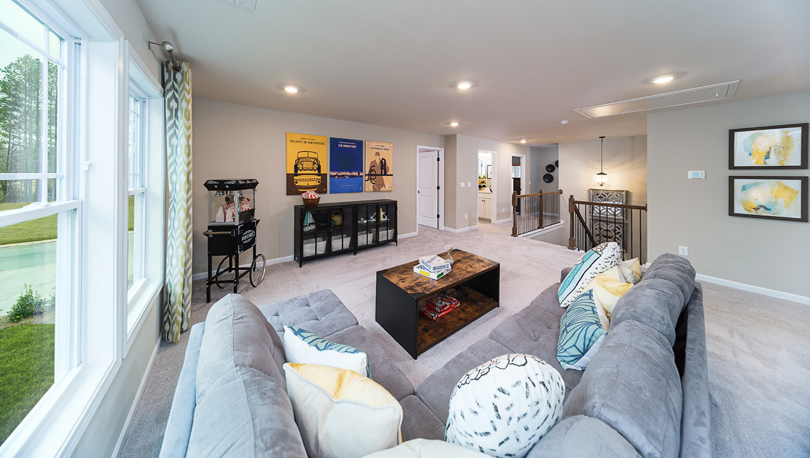 Carpeted loft upstairs with large window