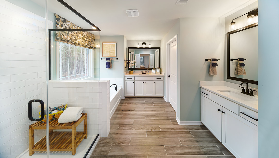 Primary bathroom with double sinks, bathtub and glass door shower