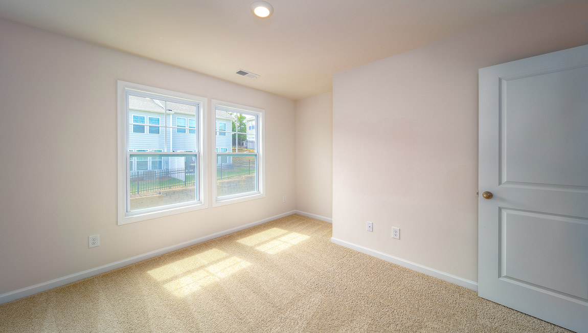 Carpeted bedroom with large windows
