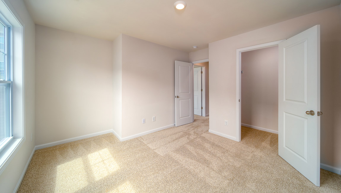 Carpeted bedroom with large windows